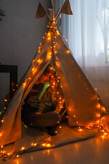 Magic tent with garland home, people inside. © Татьяна Максимова