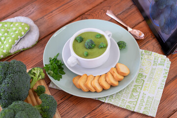 Broccoli. A green cream soup of broccoli with croutons for a healthy eating without calories but with vitamins. Concept of healthy nutrition. Wooden background