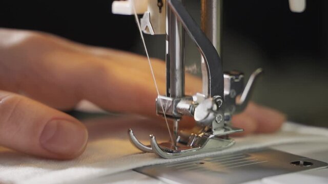 Woman using sewing machine at home.