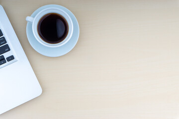 Laptop and cup of coffee on wooden background. Business and copy space concept..