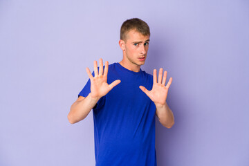 Young caucasian handsome man rejecting someone showing a gesture of disgust.