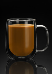 double wall glass mug with coffee on a black background with reflection