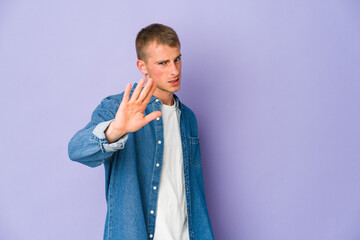 Young caucasian handsome man rejecting someone showing a gesture of disgust.