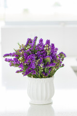 Nice flower arrangement with purple statice, decorating the spaces of a beautiful kitchen