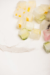 frosted vegetable and fruit cubes on white marble 