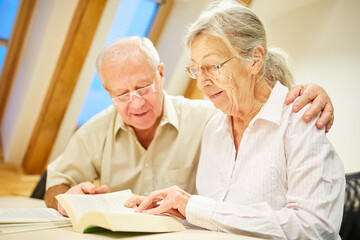 Paar Senioren mit Brille beim Buch lesen