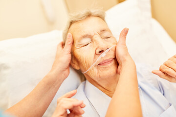 Alte Frau mit Sauerstoffbrille im Pflegeheim