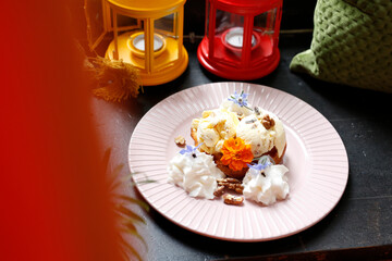 Ice cream with nuts and raisins and whipped cream.
Culinary photography. Food styling.