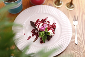 Chocolate cake with whipped cream and raspberry sauce.
Culinary photography. Food styling.