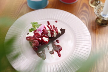Brownie with whipped cream and raspberries.
Culinary photography. Food styling.