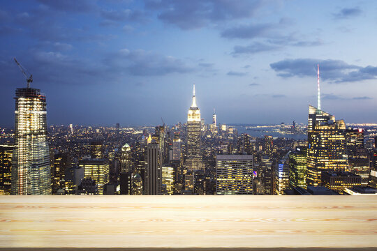 Blank tabletop made of wooden planks with beautiful New York cityscape at evening on background, mockup