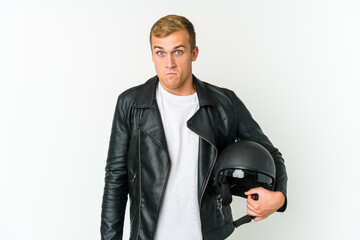 Young caucasian man holding a motorbike helmet isolated on white background