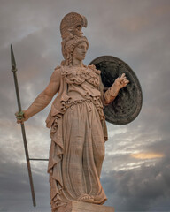 Athena, the ancient Greek goddess of knowledge and wisdom under dramatic sky, Athens Greece.