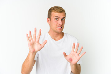 Young caucasian handsome man rejecting someone showing a gesture of disgust.