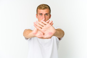 Young caucasian handsome man doing a denial gesture