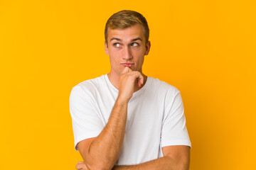 Young caucasian handsome man looking sideways with doubtful and skeptical expression.