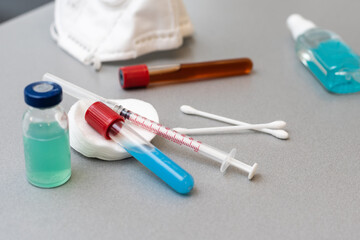 Syringes, medicine bottles on a gray background.