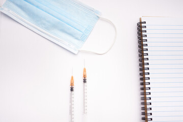 Syringes and notebook and surgical mask