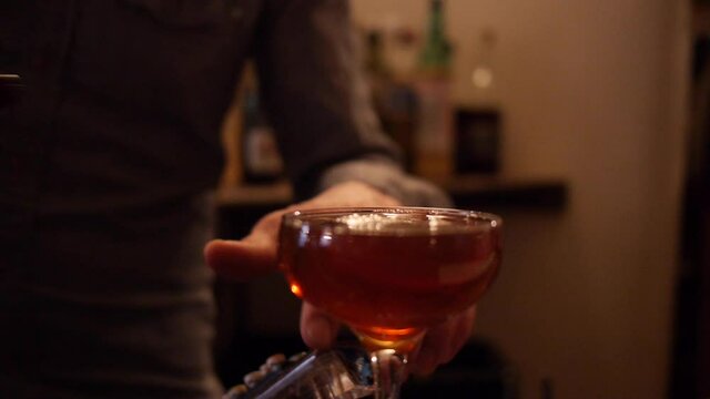 Bartender Pours Manhattan Cocktail to Serve at Bar, Mixology Dive Bar
