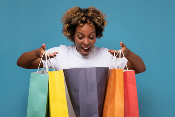 African woman with colorful shopping bags being excited with her purchases.