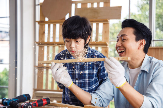 Boy Blowing Sawdust From Timber.