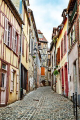 Fototapeta na wymiar Old medevial street with ancient houses and cobblestones in Old house in Joigny, Burgundy France
