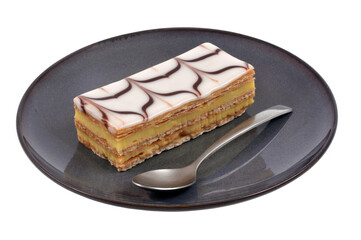 Millefeuille dans une assiette avec une cuillère en gros plan sur fond blanc