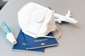 travel during the covid-19 pandemic. airplane model with face mask and travel documents