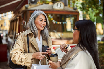 Cheerful female friends chatting on the street