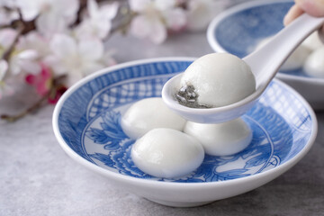 Close up of tangyuan yuanxiao in a bowl on gray table, food for Winter Solstice.