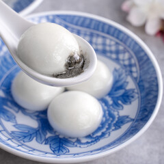 Close up of tangyuan yuanxiao in a bowl on gray table, food for Winter Solstice.
