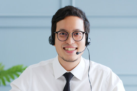 Portrait Young Asian businessman talking on video call conference or virtual meeting in office, front view, look at camera