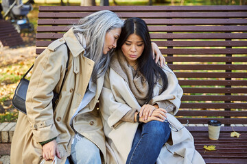 Charming woman comforting upset friend on the street