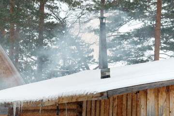 winter scenery with smoke coming from house chimneys morning, in remote countryside. selective focus