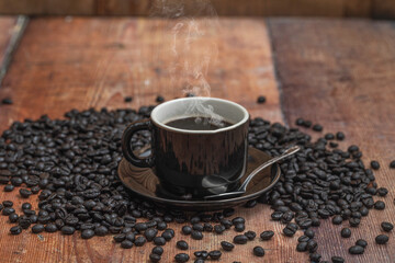 A cup of coffee with coffee beans over a wooden table.