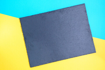 black slate on a multicolored blue and yellow background with space for copying text. mockup