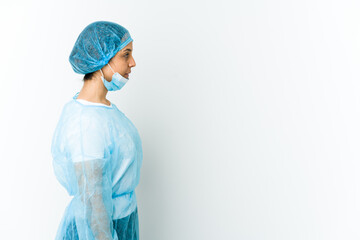 Young surgeon latin woman isolated on white background gazing left, sideways pose.