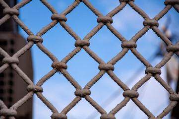 Closeup of vintage grille with shabby paint against blue sky