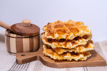 Waffles with hot maple syrup. Honey pouring on a fresh waffles.