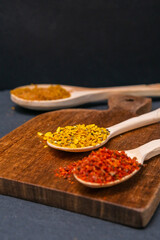 dry spices in a wooden spoon close-up on a vintage background. selective focus