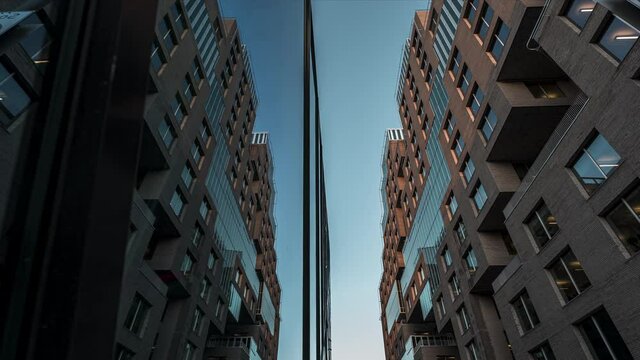 Reflective Mirror Glass Building Against Blue Sunset Sky In Barcode Project, Downtown Oslo, Norway - low angle, time lapse