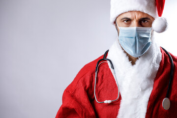 Babbo natale con mascherina chirurgica e stetoscopio al collo  guarda serio e preoccupato, isolato...