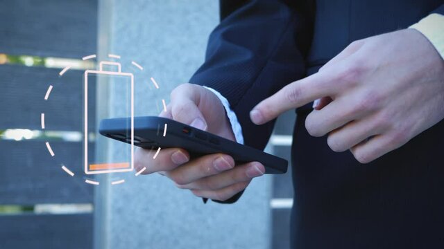 Smartphone of businessman in black suit has low battery charge. Power low warning symbol.