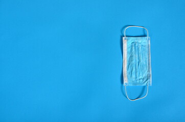 Blue Face protective masks on blue background. Copy space, covid - 19