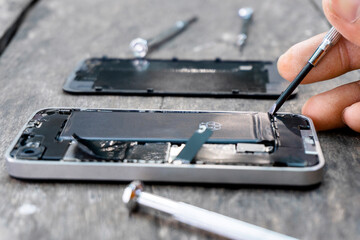The technician holding a screwdriver a mobile phone repair Closeup inside cell phone with a fixing...