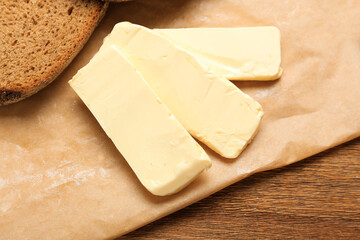 Fresh butter with bread on wooden table