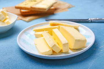 Plate with tasty fresh butter on color background