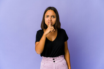 Young mixed race woman keeping a secret or asking for silence.