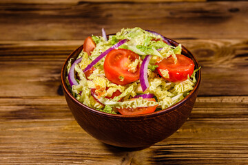Vegan salad with savoy cabbage, tomatoes and onion in a ceramic bowl