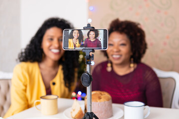 Mother and daughter recording Christmas video for family and friends. Celebrating the festivities...